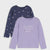 Two girls' long-sleeve tops on a light gray background. The front top is light lavender with the phrase 'Dreams come true' in white script and small pink floral accents.