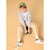 A young boy wearing a gray cardigan, beige trousers, white sneakers, a white t-shirt, and an olive green cap sits on a small stool against a solid beige background.