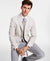 Man wearing a light gray suit with a white shirt and patterned tie on a white background