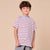 A young boy with brown hair wearing a white short-sleeve t-shirt with thin red and blue horizontal stripes, paired with gray pants, standing against a solid beige background.