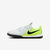 A Nike soccer turf shoe in white and neon yellow-green with a black Swoosh and black studs, shown from the side on a light gray background.
