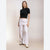 A woman modeling a black short-sleeve crop top and light heather gray wide-leg sweatpants against a plain beige studio background.