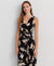 Woman wearing a black floral dress against a light gray background