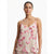 A woman modeling a light beige satin camisole top with a pink and magenta floral print, set against a plain white studio background.