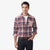 A man wearing a long-sleeve button-up plaid flannel shirt in red, navy, and beige, paired with a white t-shirt, dark blue jeans, and a brown leather belt, photographed against a solid white background.