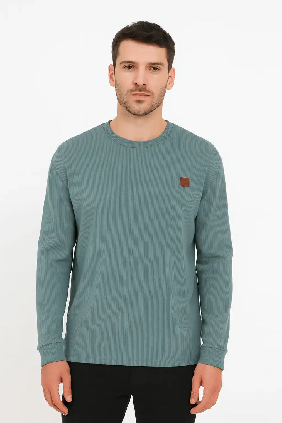 Man wearing a teal long-sleeve shirt with a small brown logo on a white background