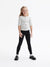 Young girl wearing a striped shirt and black leggings on a white background