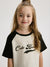 Young girl wearing a black and white shirt with 'Cute Bunny' text on a plain background