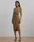 Woman wearing a green dress with a belt against a plain background