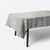 A gray textured tablecloth draped over a rectangular table with black legs, set against a clean white background.