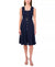 Woman wearing a navy blue dress with gold buttons on a white background