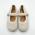 A pair of cream-colored, textured boucle Mary Jane shoes with silver-tone buckle straps, displayed on a clean white background.