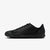 Black Nike sneaker with green swoosh logo on a white background