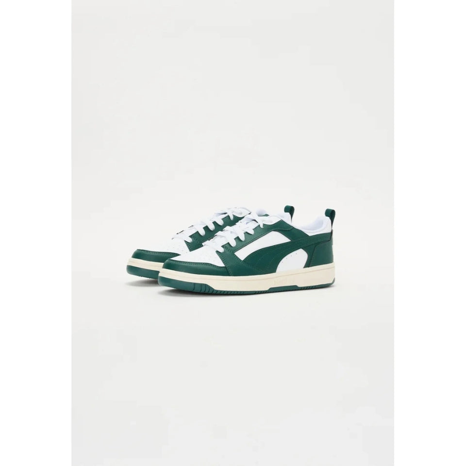 A pair of low-top sneakers in dark green and white, featuring a thick white midsole and a side logo, displayed against a clean white background.