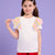 A young girl with brown hair in pigtails models a white short-sleeve t-shirt featuring pastel yellow, pink, and blue ruffled shoulder details, paired with red shorts, set against a solid lavender background.