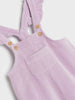 Purple corduroy overalls with button details on a light gray background
