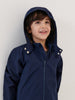 Child wearing a navy blue raincoat against a plain background