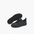 A pair of black Puma sneakers shown on a clean white background, with one shoe standing upright to display the side profile and the other lying on its side to show the textured black sole.