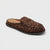 A single slip-on loafer-style mule shoe in brown and black leopard print with a dark sole, photographed on a clean light gray background.