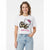 A woman modeling a white short-sleeve graphic t-shirt featuring Hello Kitty in a black and brown leopard print dress with a pink bow and the text 'Hello Kitty' in pink. She is wearing light wash blue jeans against a clean white background.