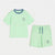 A two-piece kids' loungewear set in mint green, featuring a short-sleeve ringer t-shirt with a contrasting blue crew neck and a matching pair of drawstring shorts with blue drawstrings and a small chest graphic.