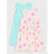 Two sleeveless children's dresses by Baby Phat, shown flat-laid on a light gray background. The front dress is pale pink with a pink and green palm tree print, and the back dress is light aqua blue.