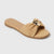 Beige sandal with a gold bow on a light gray background