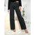 A person wearing black wide-leg jeans with a faded wash, paired with a black sequined long-sleeve crop top and metallic heeled sandals, standing on a white shag rug in a bright indoor setting.