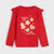 A red long-sleeve children's top with ruffled shoulder details, featuring a festive graphic of gingerbread cookies, stars, and hearts with the text 'Christmas is cute like gingerbread' on a light gray background.
