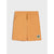 A pair of kids' shorts in a warm mustard yellow color, featuring an elastic waistband with a drawstring and a small square graphic patch on the lower left leg, shown against a light gray background.