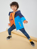 Child wearing a colorful jacket and jeans on a plain background