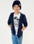 Child wearing a navy hoodie, white t-shirt with graphic design, and blue jeans on a light gray background