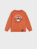 Orange sweatshirt with a cartoon design on a white background