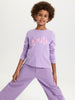 Child wearing a purple outfit with 'Smile' text on a white background