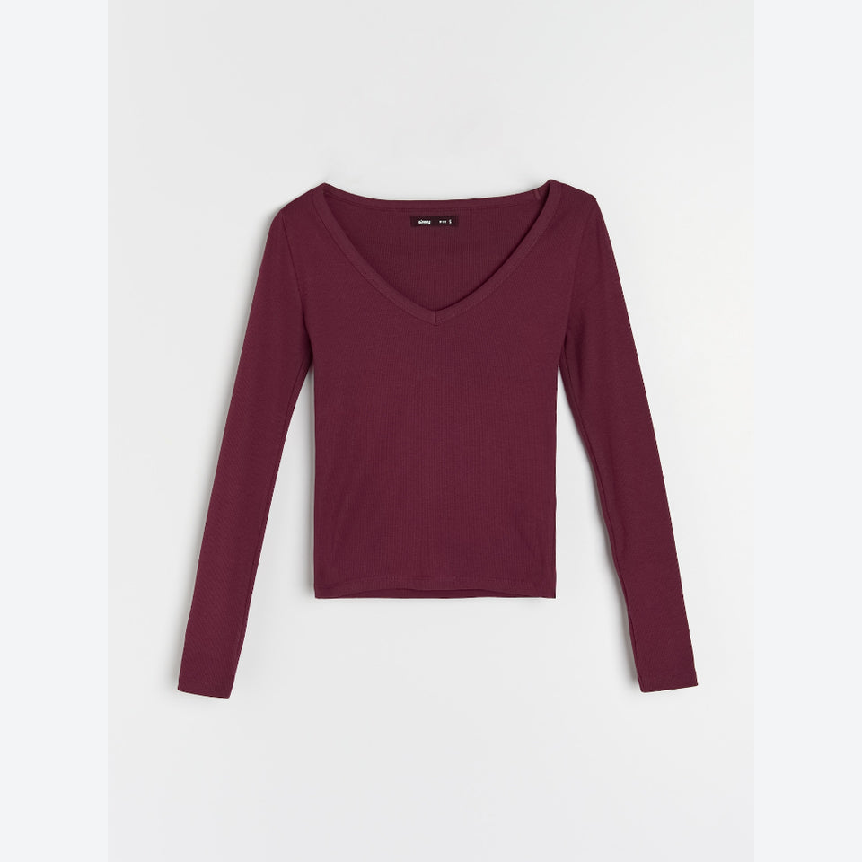 A long-sleeve crop top in a deep burgundy or maroon color, featuring a wide scoop V-neck, laid flat against a light gray background.