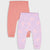 Two pairs of baby leggings laid flat on a light gray background. The back pair is solid coral pink, and the front pair is light lavender with a pink paisley and heart pattern.