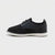 A black knit and leather lace-up sneaker with a white sole, shown in a side profile on a light gray background.