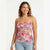 A woman modeling a floral spaghetti-strap camisole top with a sweetheart neckline, paired with light-wash jeans, against a plain white studio background.
