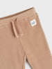 Beige corduroy pants with a small label on a white background