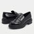 A pair of glossy black leather penny loafers with chunky lug soles, shown from the side and back on a light gray background.