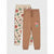 Two pairs of kids' sweatpants laid flat on a light gray background. The front pair is tan with a small colorful dinosaur graphic on the left thigh.