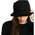 A woman wearing a black bucket hat with fuzzy trim and a small 'STENEMANIER' logo on the front, photographed against a plain white background.