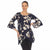 A woman modeling a navy blue tunic top with a cream floral print and flared bell sleeves, paired with black pants, against a plain white background.
