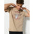A man wearing a beige crewneck t-shirt with a circular graphic of a skeletal hand holding chopsticks with the text 'BLACK MASH' and flames, set against a plain light gray background.