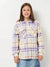 Person wearing a plaid shirt with purple and white pattern on a plain background