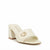 A single cream-colored heeled mule sandal by GUESS, featuring a square toe, a block heel, and a gold-tone G logo on the strap, set against a plain white background.