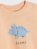 Children's t-shirt with a blue dinosaur and 'ROARR' text on a light pink background