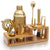 Gold cocktail shaker and bar tools on a wooden stand with a white background
