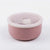 A round pink container with a matching translucent pink lid and a small flip-up tab, photographed on a clean white background.
