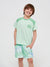Child wearing a green t-shirt and shorts with a logo on a white background